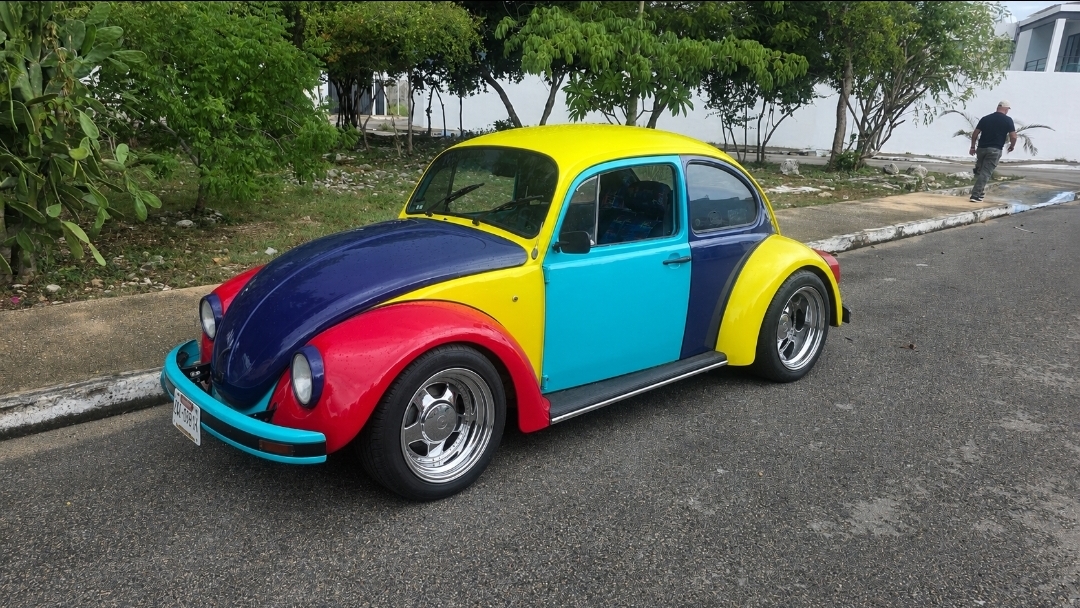 Multi-color wide body VW Beetle with flared fenders and wide chrome wheels
